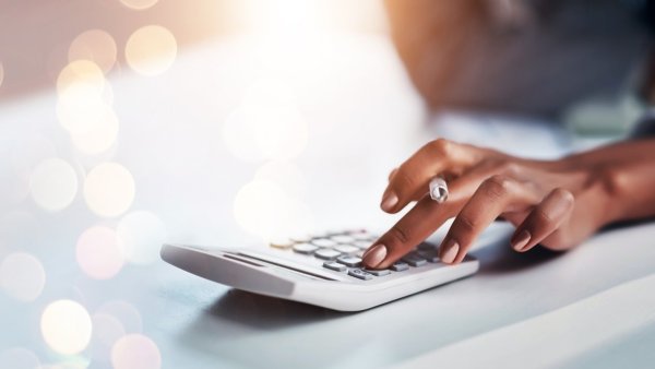 Image of woman pressing buttons on a calculator. 